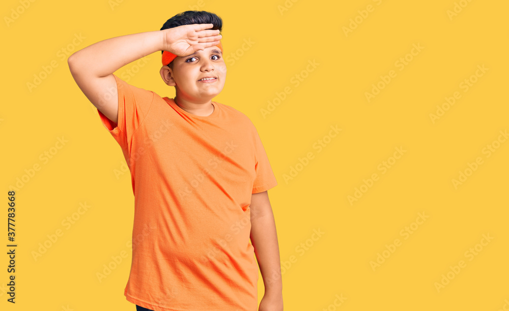 Little boy kid wearing sportswear very happy and smiling looking far away with hand over head. searching concept. Little boy kid wearing sportswear very happy and smiling looking far away with hand over head. searching concept.