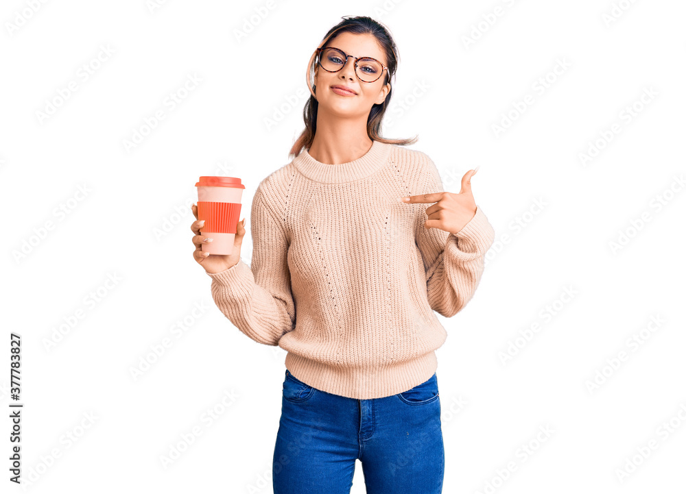 Young beautiful woman wearing glasses holding takeaway cup of coffee pointing finger to one self smiling happy and proud Young beautiful woman wearing glasses holding takeaway cup of coffee pointing finger to one self smiling happy and proud