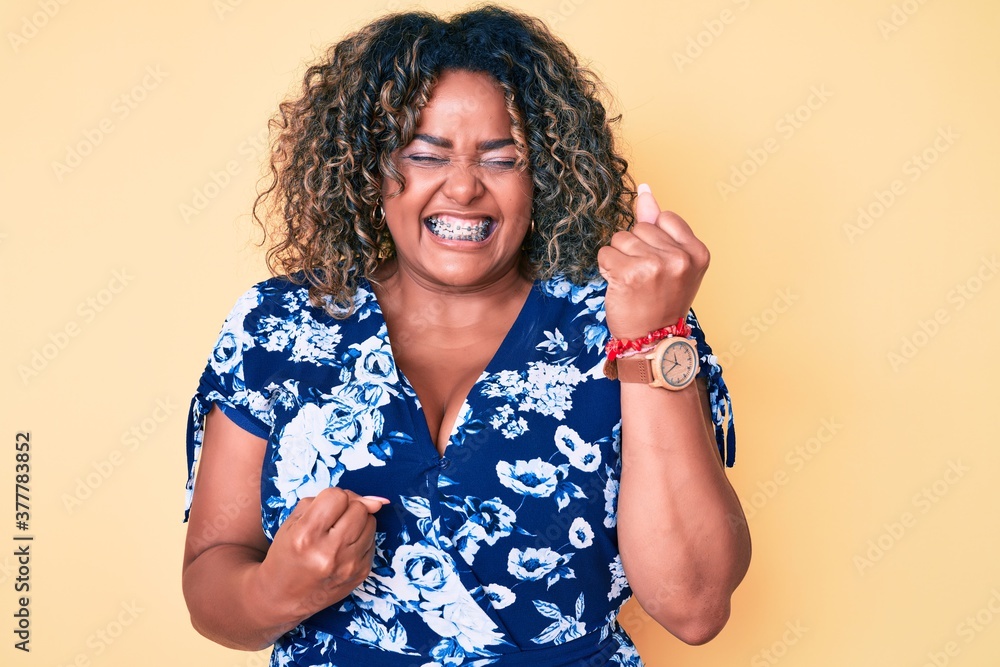 Young african american plus size woman wearing casual clothes celebrating surprised and amazed for success with arms raised and eyes closed Young african american plus size woman wearing casual clothes celebrating surprised and amazed for success with arms raised and eyes closed