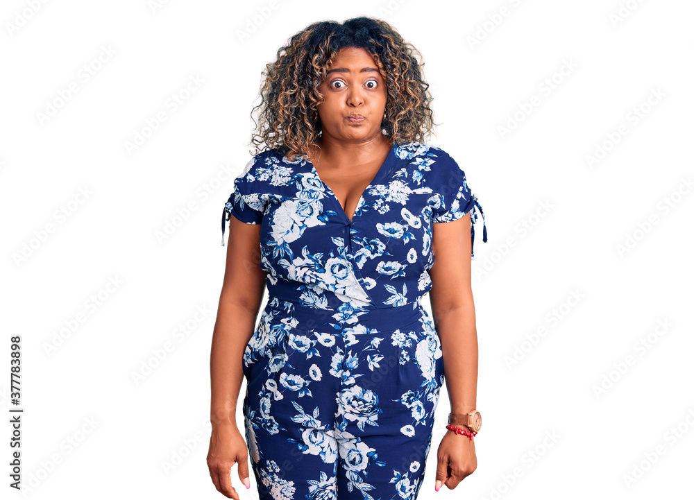 Young african american plus size woman wearing casual clothes puffing cheeks with funny face. mouth inflated with air, crazy expression. Young african american plus size woman wearing casual clothes puffing cheeks with funny face. mouth inflated with air, crazy expression.