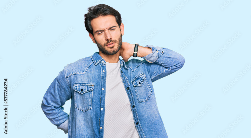 Fototapeta premium Young hispanic man wearing casual clothes suffering of neck ache injury, touching neck with hand, muscular pain