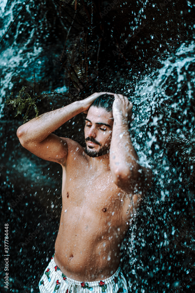 Joven atractivo en cascada mojandose Joven atractivo en cascada mojandose