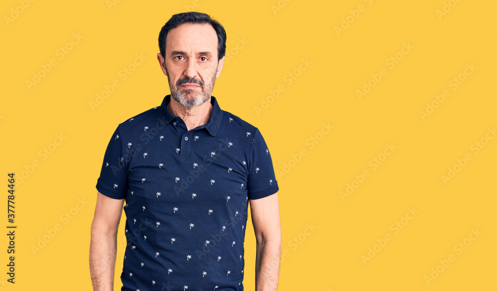Middle age handsome man wearing casual polo with serious expression on face. simple and natural looking at the camera.