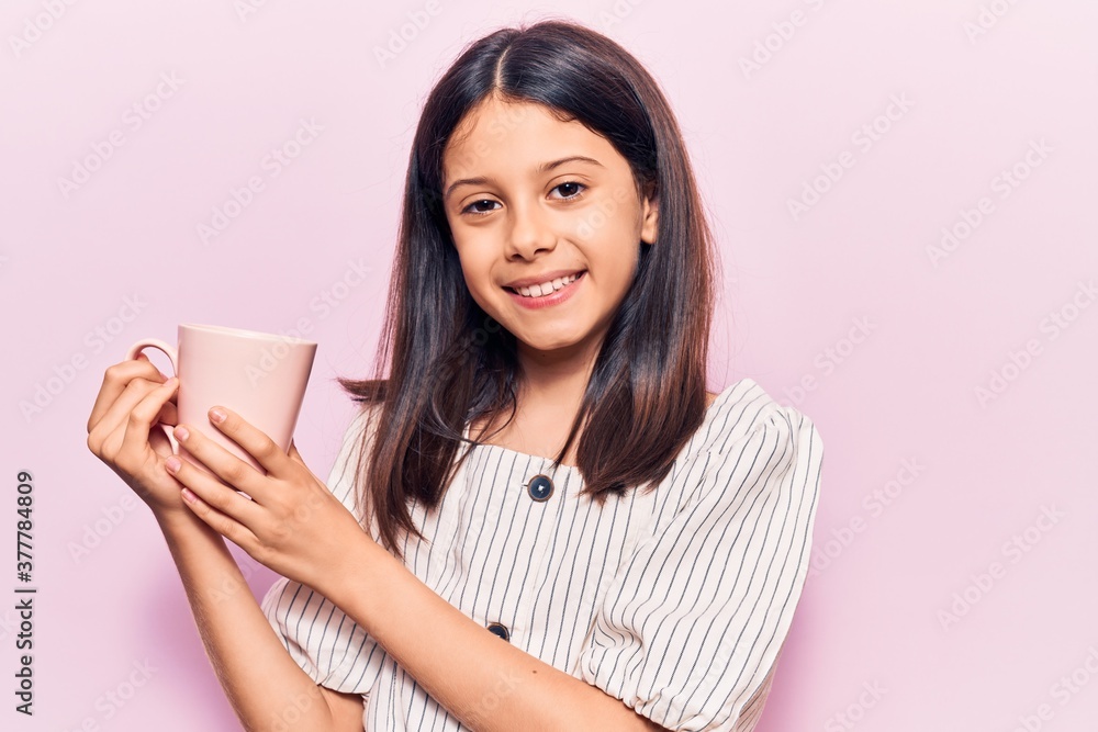 Beautiful child girl holding coffee looking positive and happy standing and smiling with a confident smile showing teeth Beautiful child girl holding coffee looking positive and happy standing and smiling with a confident smile showing teeth