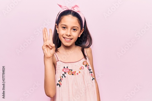 Beautiful child girl wearing casual clothes showing and pointing up with fingers number three while smiling confident and happy.
