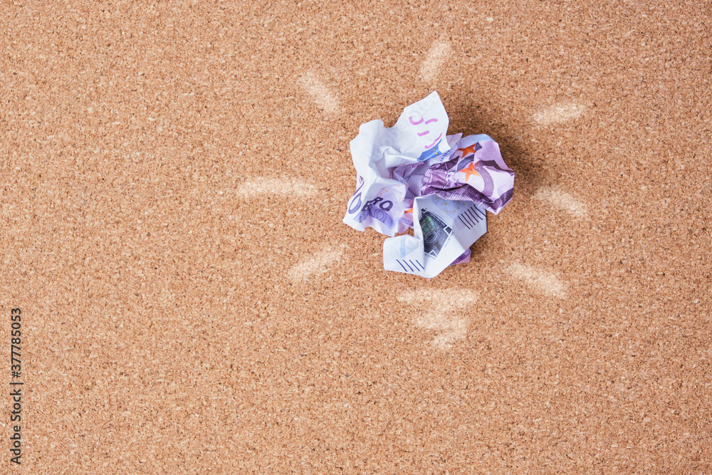 Concept idea of saving money.crumpled 500 euro bill on cork board background Concept idea of saving money.crumpled 500 euro bill on cork board background