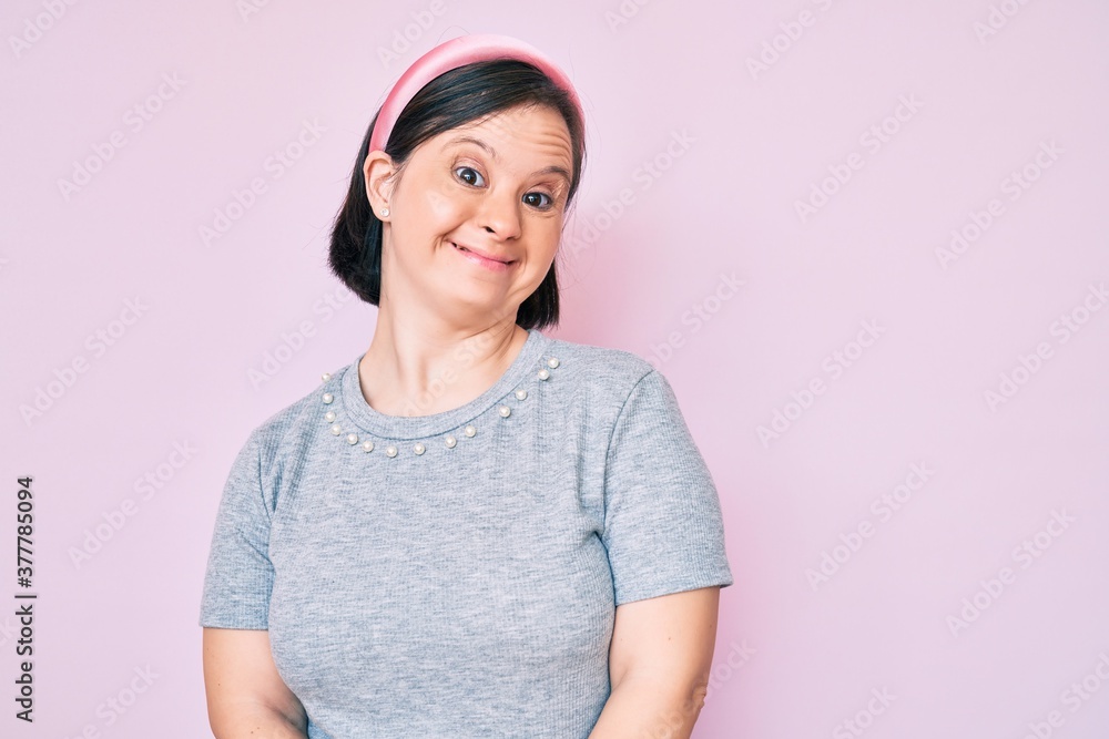Brunette woman with down syndrome wearing casual clothes looking positive and happy standing and smiling with a confident smile showing teeth