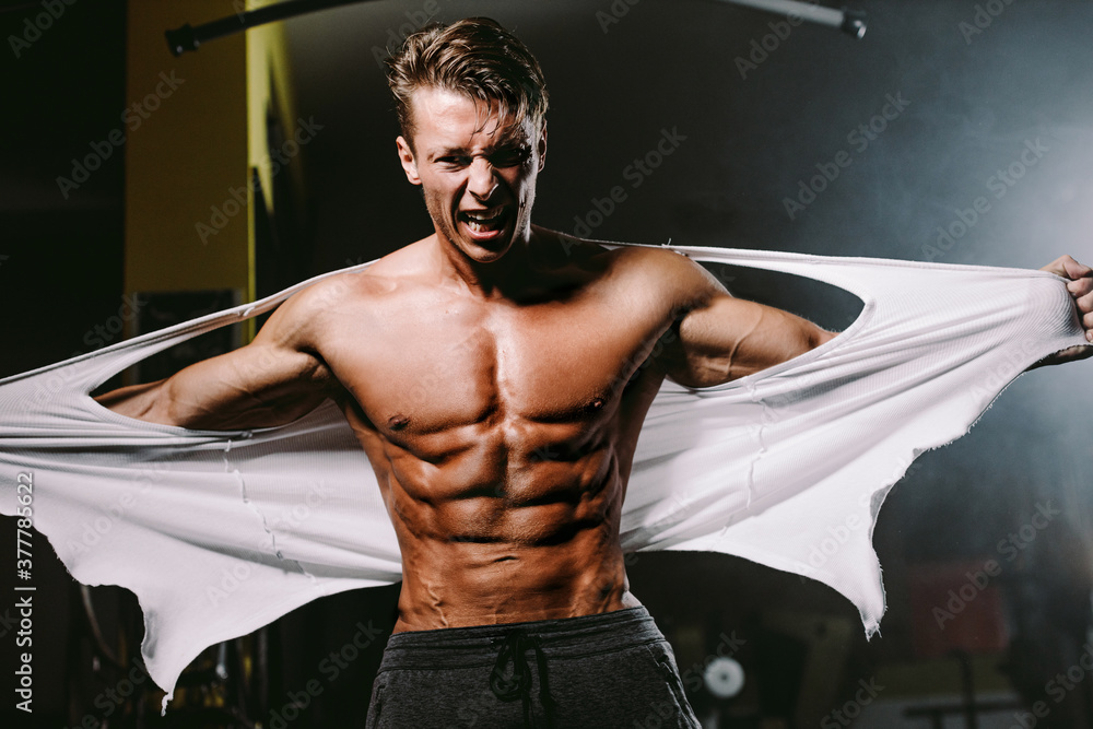 Powerful Muscular man with six pack abs. Bodybuilder man pumping