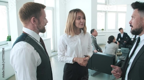 Wallpaper Mural Handheld arc shot of young woman and her male colleagues standing together and talking about something Torontodigital.ca
