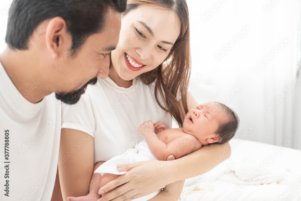 smiling mother and father holding their newborn baby at home..portrait of happy family at home, young parents holding on hands little sweet newborn baby, love and happiness concept. smiling mother and father holding their newborn baby at home..portrait of happy family at home, young parents holding on hands little sweet newborn baby, love and happiness concept.