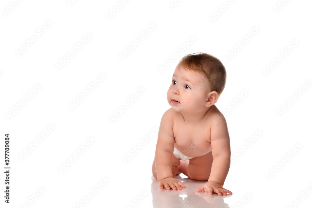 Baby crawling on floor looking aside front view Baby crawling on floor looking aside front view