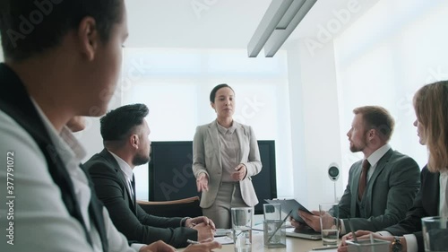 Wallpaper Mural Modern businesswoman standing at table in front of her coworkers sharing new project concepts with them Torontodigital.ca