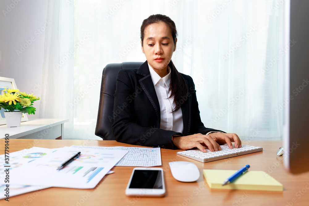 Asian business women analysis paper chart and typing keyboard insert data to computer at office. Business people working at home with internet Asian business women analysis paper chart and typing keyboard insert data to computer at office. Business people working at home with internet