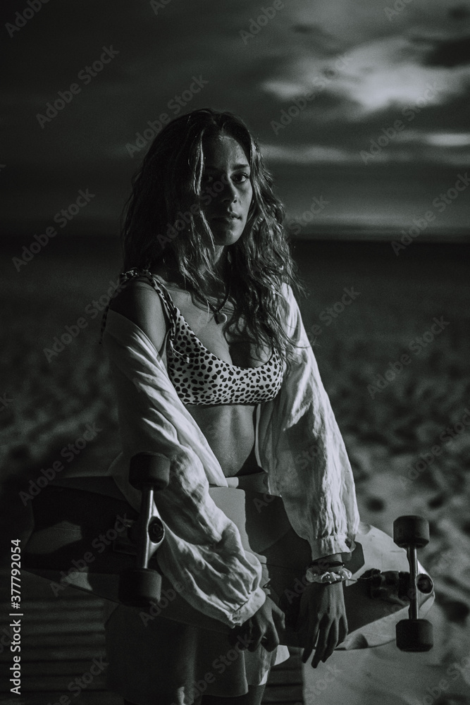 Chica veraniega morena en la playa naturaleza cañas de bambu con skateboard y bikini disfrutando de la hora dorada del atardecer Chica veraniega morena en la playa naturaleza cañas de bambu con skateboard y bikini disfrutando de la hora dorada del atardecer
