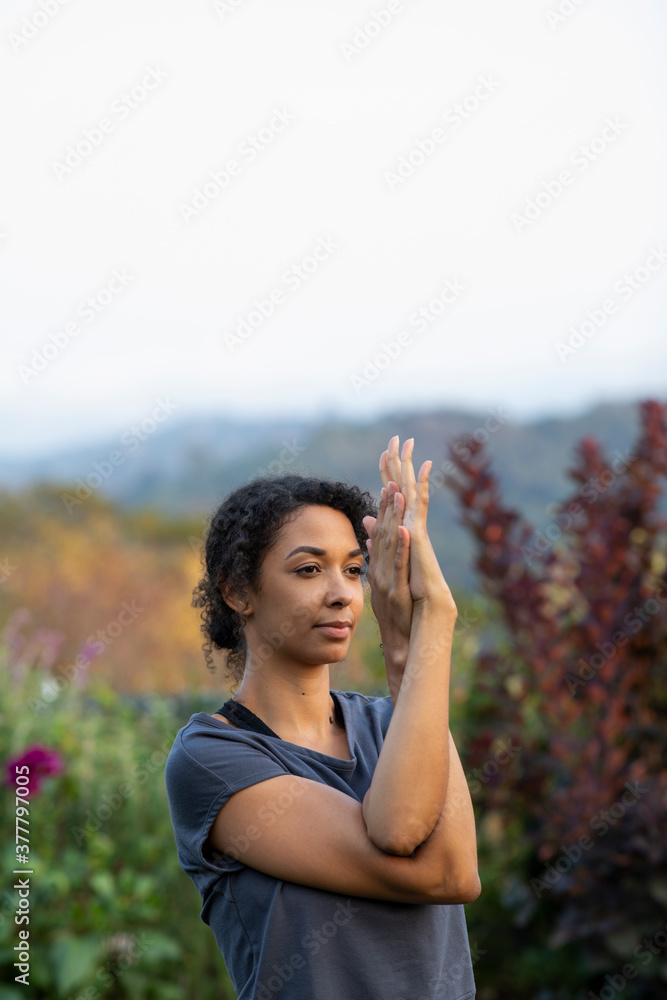 Black woman practicing yoga outdoors in garden Black woman practicing yoga outdoors in garden