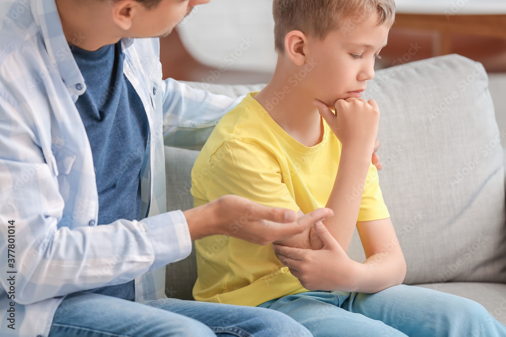 Fototapeta premium Father trying to make peace with son after quarrel at home