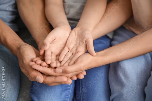 Family holding hands together at home  closeup