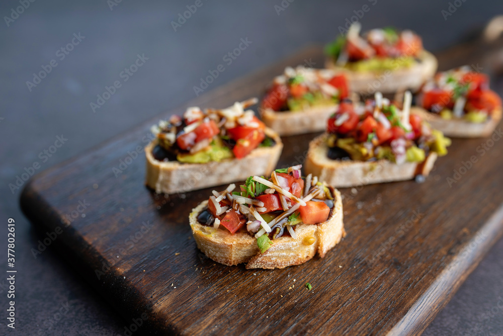 Bruschetta Sandwich served as an appetizer with tomato, avocado, onion and balsamic glaze