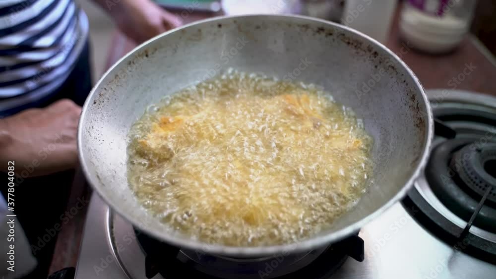 Frying Sliced Onions Coated With Gram Flour Mixture In A Wok With Cooking Oil - close up Frying Sliced Onions Coated With Gram Flour Mixture In A Wok With Cooking Oil - close up