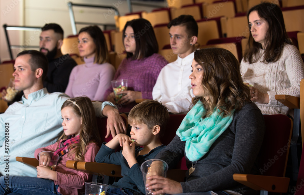 Fototapeta premium A group of people eating popcorn and enjoy watching movie in the cinema