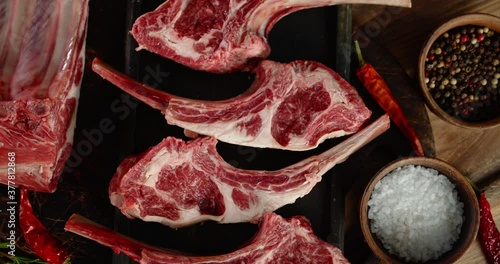 Pieces of raw rack of lamb with chilli and spices rotates.