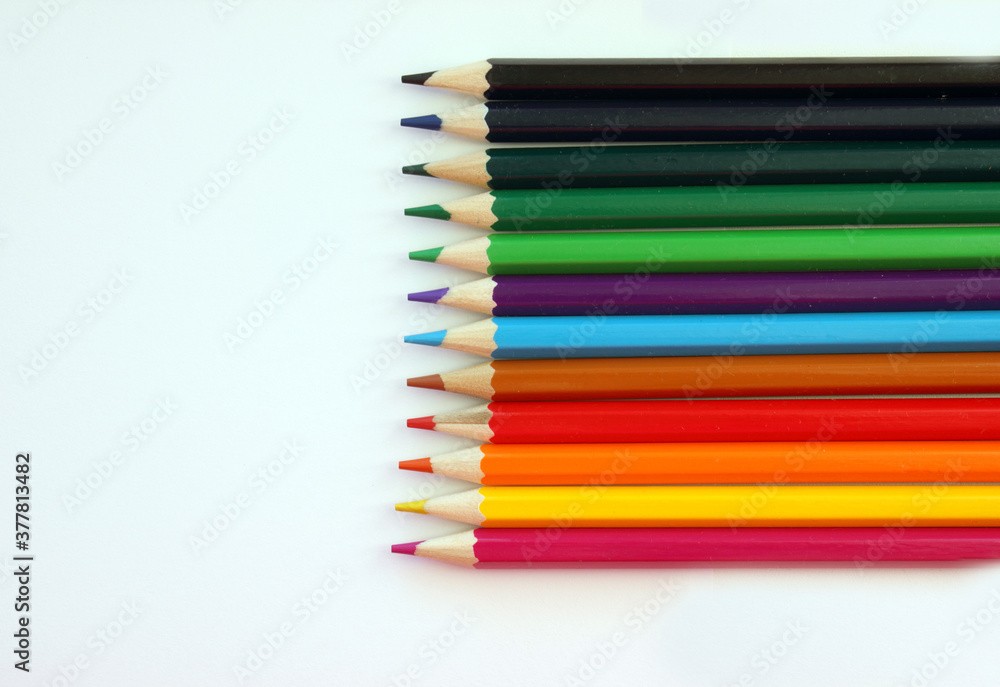 Colored pencils on a white background. Lots of different colored pencils. Colored pencil. Pencils are very sharp. Pencils are on the right, exactly. Close-up. Copy space. Background. Flat lay Colored pencils on a white background. Lots of different colored pencils. Colored pencil. Pencils are very sharp. Pencils are on the right, exactly. Close-up. Copy space. Background. Flat lay