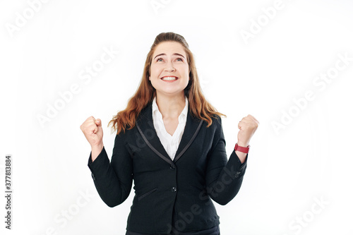 Portrait of happy excited young businesswoman celebrating success and looking up