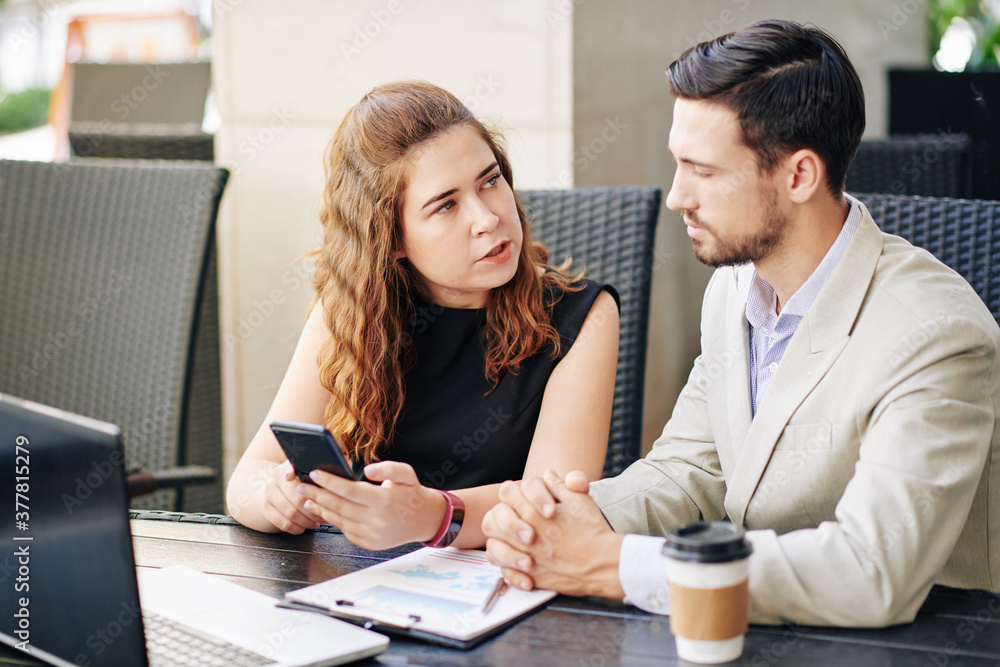 Young female entrepreneur asking coworker for advice when they are having meeting in cafe Young female entrepreneur asking coworker for advice when they are having meeting in cafe