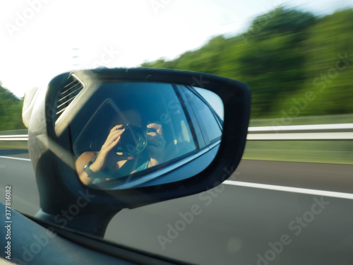 young woman taking a picture of a rearview