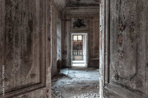 Abandoned mansion interior. Half open grunge doors. Old palace enfilade. Spooky haunted house concept. photo