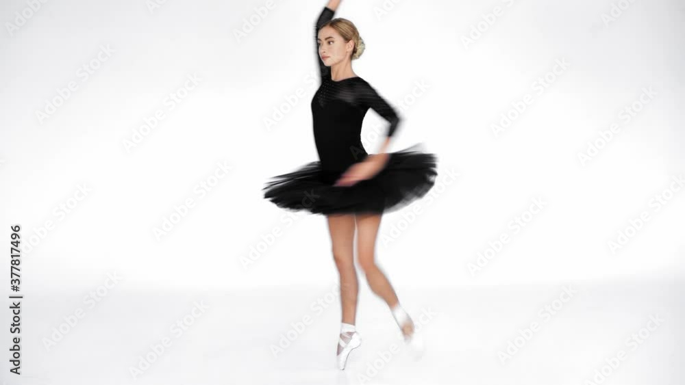 Young ballerina in black ballet skirt spinning and dancing on white background Young ballerina in black ballet skirt spinning and dancing on white background