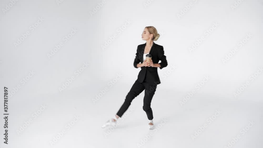 Young ballerina walking on pointe with paper cup of coffee on white background Young ballerina walking on pointe with paper cup of coffee on white background