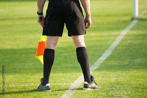 Assistant football referee with flag on the football field during a match