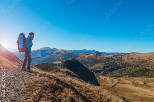 Hiker on the mountain top enjoys the view.