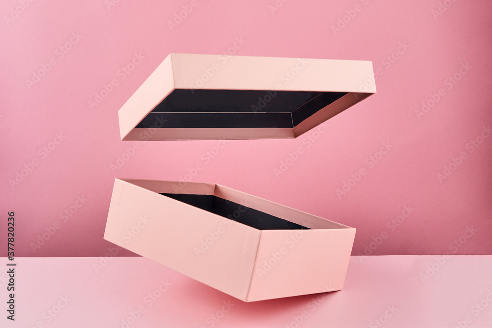 Pink open gift box isolated on pink background. Empty gift container. Blank Mock up with flying box. - obrazy, fototapety, plakaty 