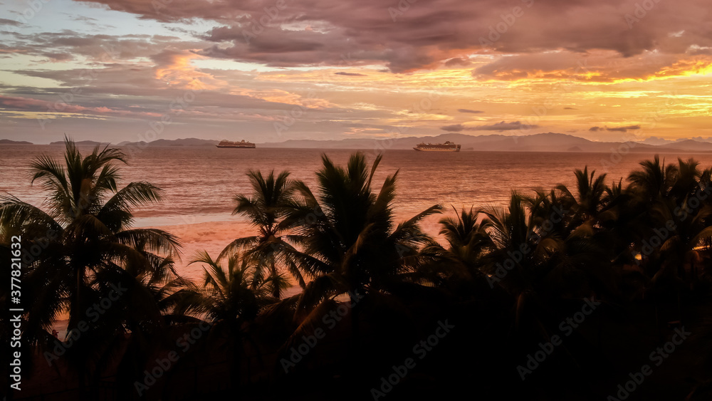 Beautiful aerial view of the majestic sunset with palm trees, ocean and cruise ships in Costa Rica Beautiful aerial view of the majestic sunset with palm trees, ocean and cruise ships in Costa Rica