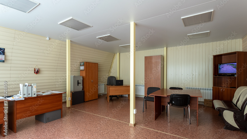 Office with dark wooden tables, wardrobes and chairs for guests Office with dark wooden tables, wardrobes and chairs for guests