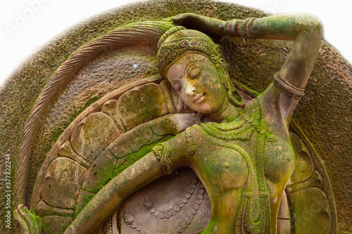 A statue of an angel, a fairy woman, a fairy woman in fairy tales or bare-busted literature on display outdoors. Exposed to rain and moisture, green moss was formed throughout the body.
