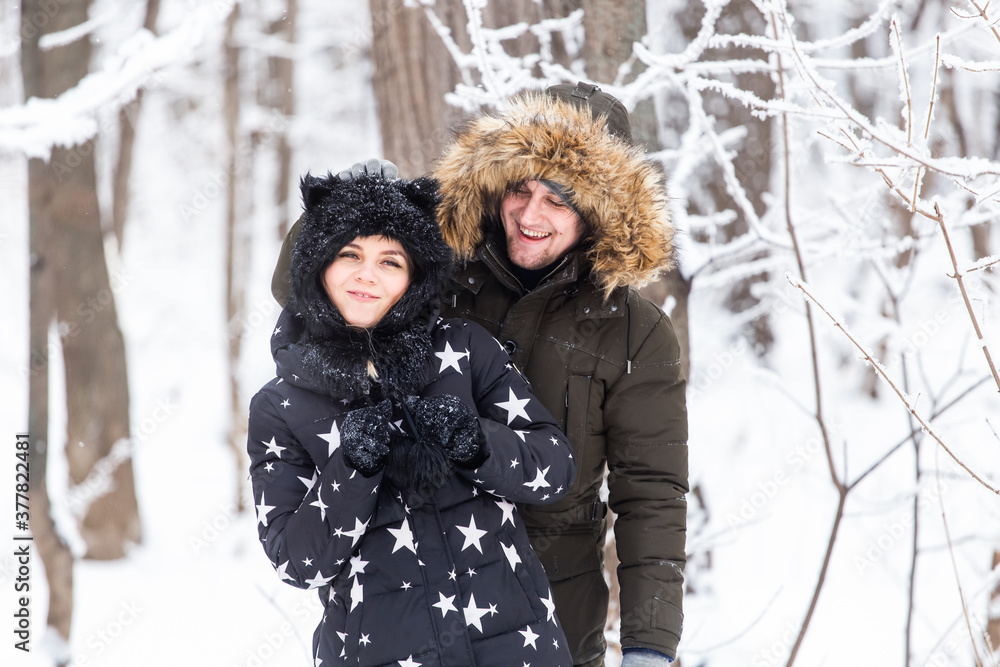 Fun, season and leisure concept - love couple plays winter wood on snow Fun, season and leisure concept - love couple plays winter wood on snow