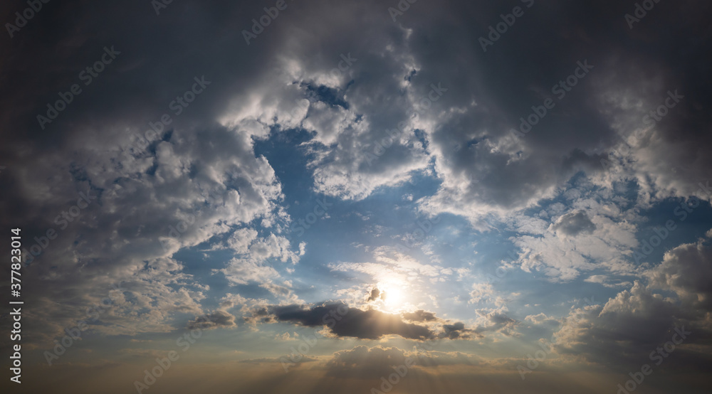 Summer sunset sky with sunshine and fleece colorful clouds. Evening dusk good weather natural background Summer sunset sky with sunshine and fleece colorful clouds. Evening dusk good weather natural background