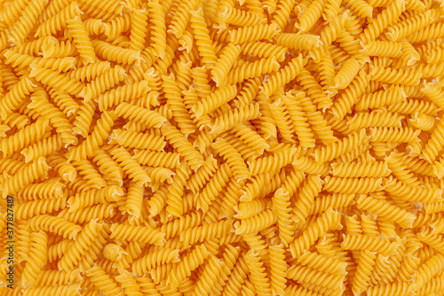 Uncooked fusilli pasta background. Close up of raw fusilli pasta