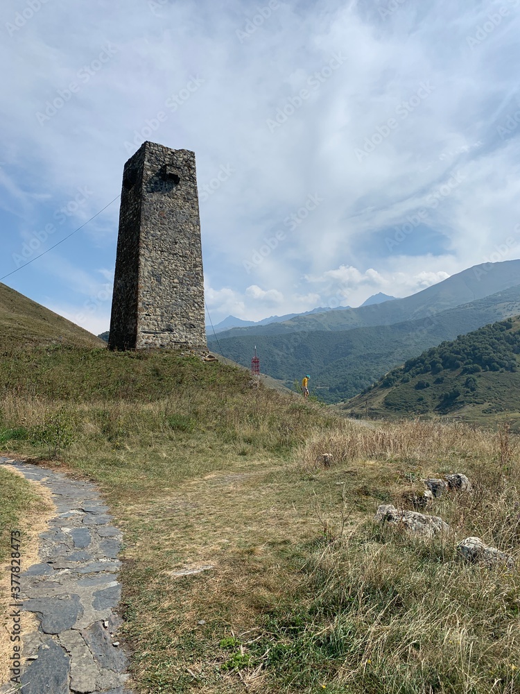 Old tower in mountains, sky background
