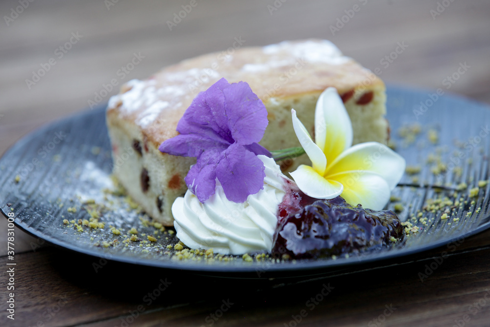 Raisin bread decorated with edible flowers served on the wooden table	