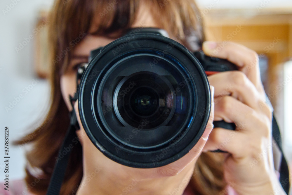 Camera in the hands of a female photographer-close-up full-face lens. Camera in the hands of a female photographer-close-up full-face lens.