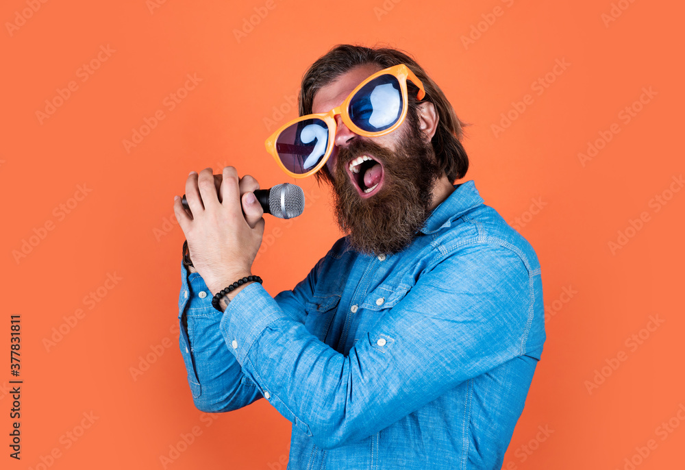 sing to the rhythm of your heart. concept of music. performer having fun. mature bearded man in funny party glasses sing song. brutal male hipster with microphone. vocal school. favorite music style sing to the rhythm of your heart. concept of music. performer having fun. mature bearded man in funny party glasses sing song. brutal male hipster with microphone. vocal school. favorite music style