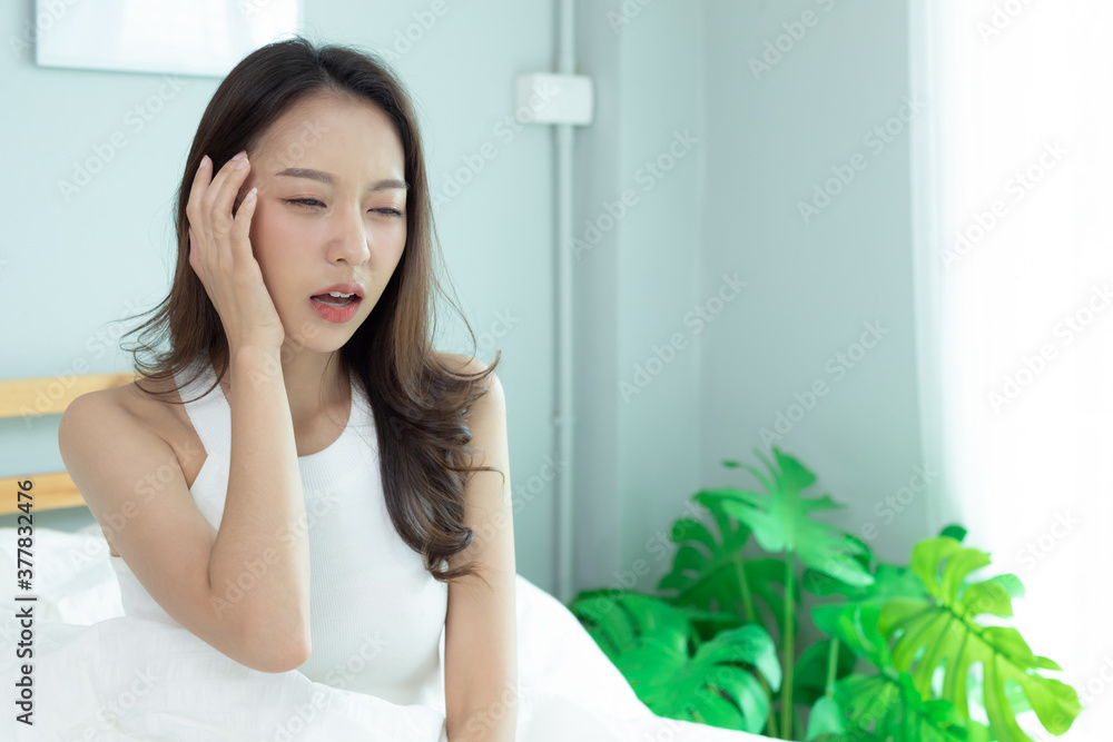 Women have pain head sit on bed after work out. Women have pain head sit on bed after work out.