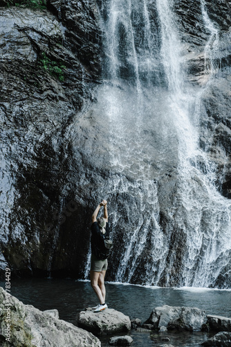 young woman on the background of a mountain waterfall with a ponytail 