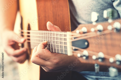 Close up of Man hands playing on acoustic Guitar. 
