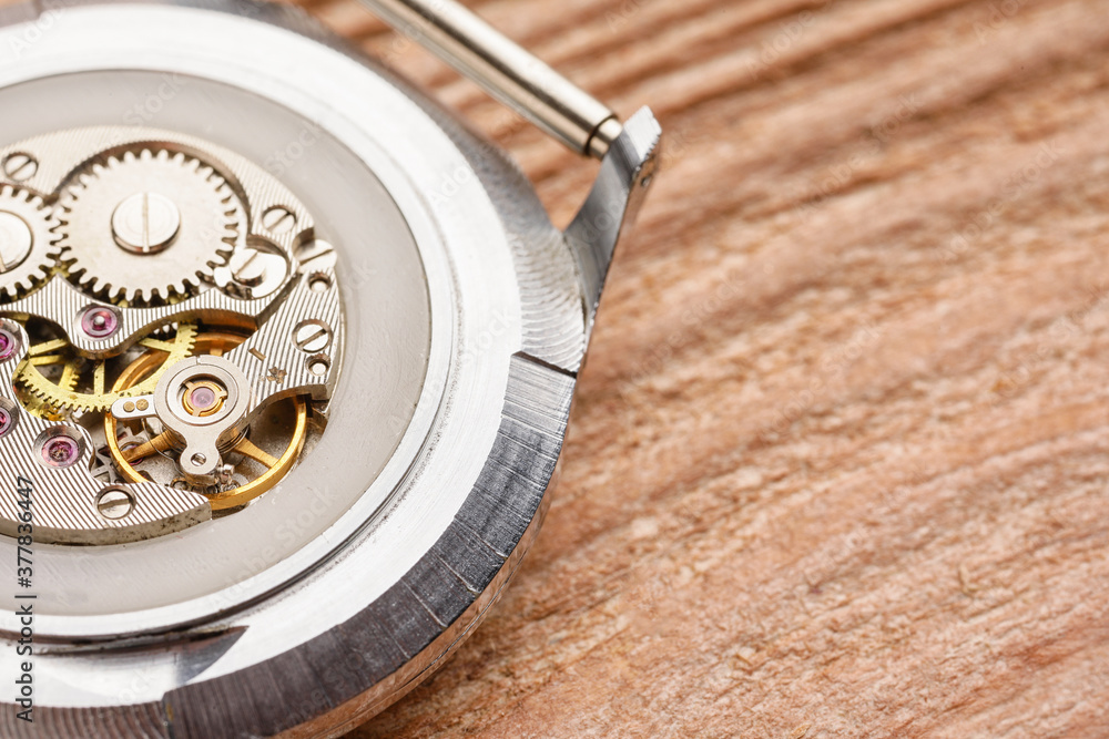 Disassembled watch on wooden background, closeup