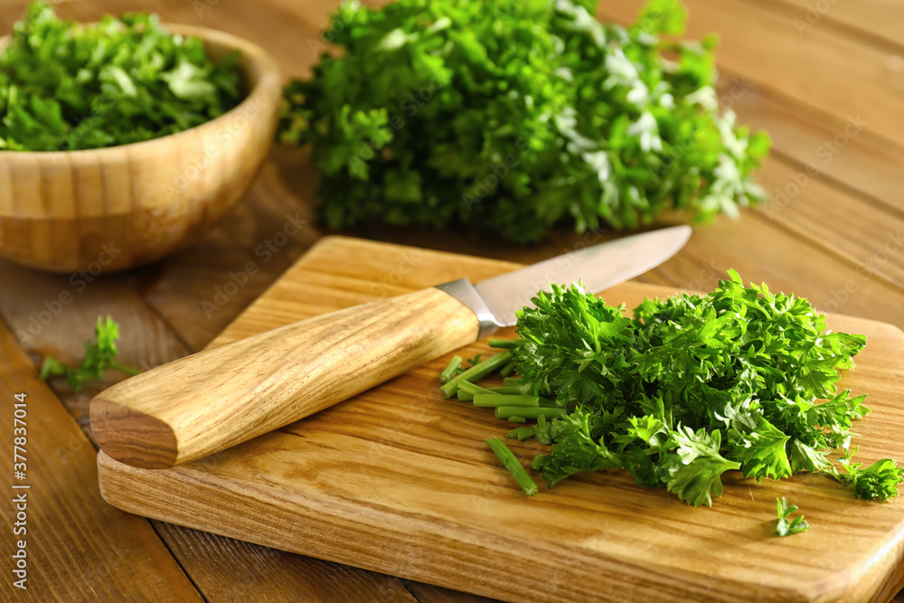 Fresh parsley, cutting board and knife on wooden background Fresh parsley, cutting board and knife on wooden background